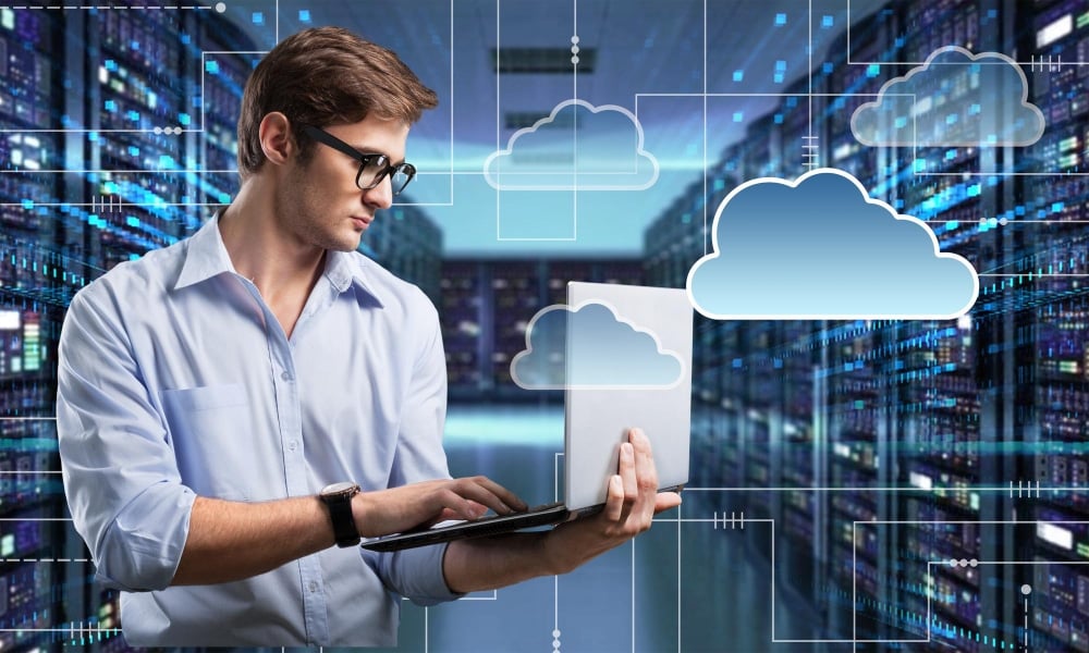 Cloud Services 1 A man using a laptop to access a cloud server.